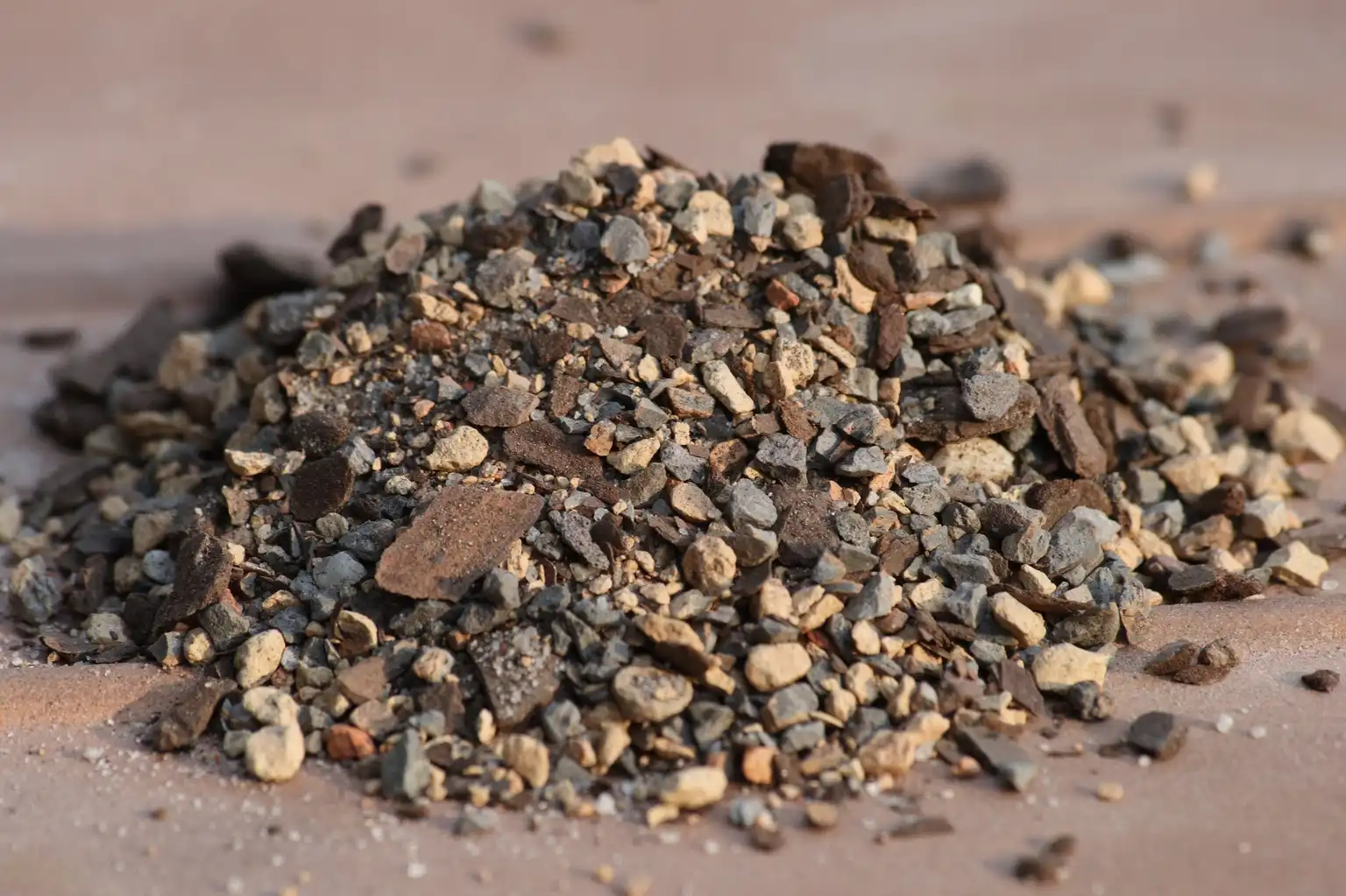 Hand mixing akadama, pumice, and lava rock in a tray to show bonsai soil texture.