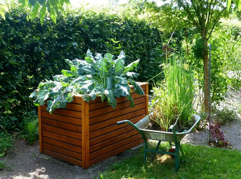 Raised bed garden setup with soil, compost, mulch, and watering can in natural light
