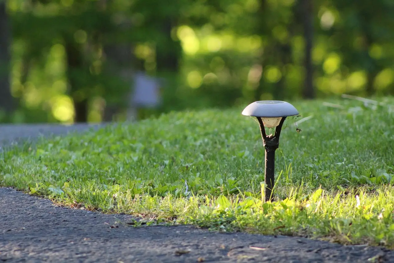 Suburban driveway at dusk with low bollard lights guiding cars and a softly lit pedestrian path